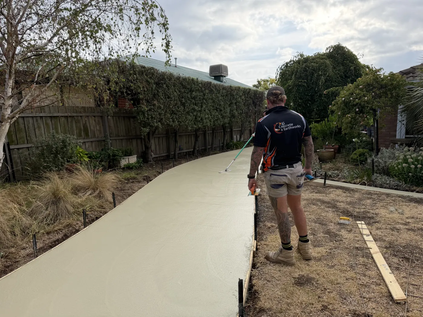 LG Concrete & Earthworks team member finishing curved concrete pathway